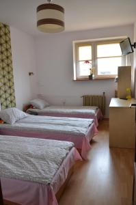 eine Reihe von Betten in einem Zimmer in der Unterkunft Apartament Tolek in Warschau