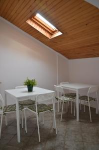 a room with white tables and chairs and a skylight at Apartament Tolek in Warsaw