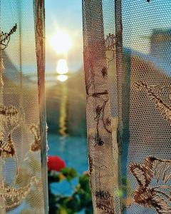 リミニにあるHotel Alcazarのカーテン付きの窓から海の景色を望めます。