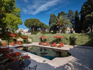 una piscina con sedie e ombrelloni di Palazzo Margherita a Bernalda