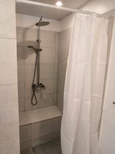W łazience znajduje się prysznic z białą zasłoną prysznicową. w obiekcie The Blue Gate 2 w Maskacie