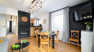 a kitchen and living room with a table and chairs at VacationClub - Komuny Paryskiej 30 Apartament 3 in Karpacz