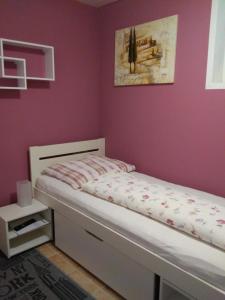 1 dormitorio con cama y pared púrpura en Ferienwohnung Anita Benz, en Thurmansbang