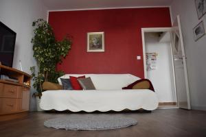 a white couch in a room with a red wall at Apartments BrunoR in Dubrovnik