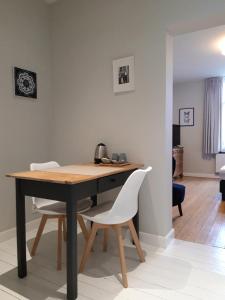 特納維耶的住宿－L'Aubier，一张桌子、两把白色椅子和一张木桌