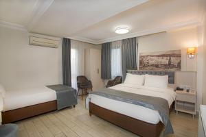 イスタンブールにあるSim Hotelのベッド2台とデスクが備わるホテルルームです。