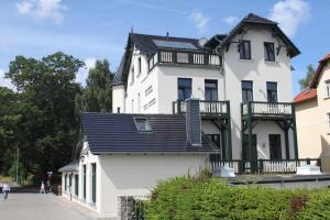 a large white house with a black roof at Hotel Villa Sommer in Bad Doberan