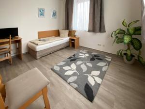 - un salon avec un lit et un tapis dans l'établissement Hotel-Stadt-Aschersleben, à Aschersleben