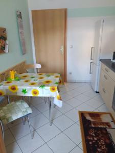 a kitchen with a table with a tablecloth with sunflowers on it at Ferienwohnung am Tierpark Weißwasser in Weißwasser