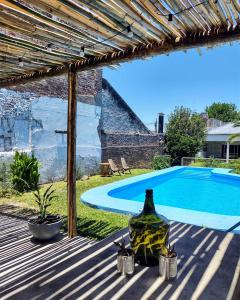 a bottle of wine sitting on a table next to a swimming pool at El Bicho Negro Hostel in Concordia