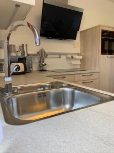 a stainless steel sink in a kitchen with a tv at Haus Martina in Sand in Taufers