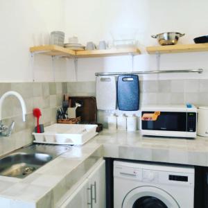 a kitchen with a sink and a washing machine at The Blue Gate 2 in Muscat