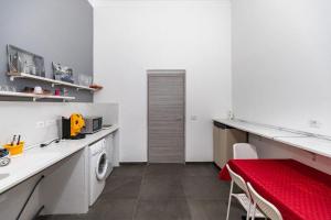a kitchen with a washing machine and a red table at B&B Verga in Catania