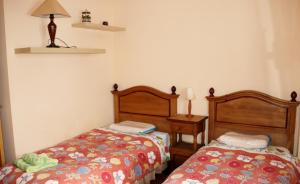 a bedroom with two beds and a table with a lamp at Paseo del Muelle 2, 3º D Reg VUT 706AS8 in Luarca