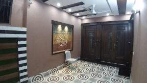 a room with a hallway with a door and a chair at Al-Nafay Guest House R1 in Lahore