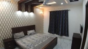 a bedroom with a bed and a ceiling fan at Al-Nafay Guest House R1 in Lahore