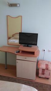 a desk with a television on it with a mirror at Family Hotel Coral in Sozopol