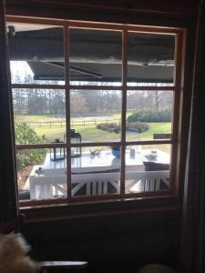 a window with a view of a table and a yard at The Swiss hut 30 minutes from Copenhagen in Kvistgård