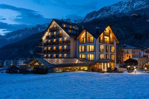 ein großes Gebäude im Schnee bei Nacht in der Unterkunft Hotel Sant'Orso - Mountain Lodge & Spa in Cogne