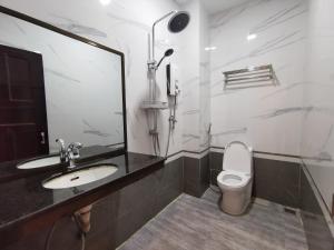 a bathroom with a sink and a toilet at Invito Guesthouse in Sihanoukville