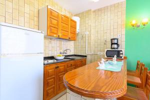 a kitchen with a wooden table and a refrigerator at Palmasol Apartamentos in Puerto Rico de Gran Canaria