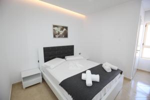 een slaapkamer met een bed met een kruis erop bij Nika Hotel in Sarandë