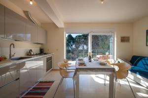 kuchnia ze stołem i krzesłami oraz oknem w obiekcie Apartment Manto Free Parking w Rovinj