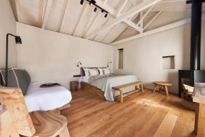 a bedroom with two beds and a fireplace at Ruga of Vamvakou Homes in Vamvakoú