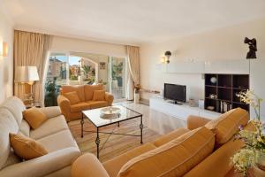 sala de estar con 2 sofás y TV en Hacienda Playa Elviria Marbella, en Marbella