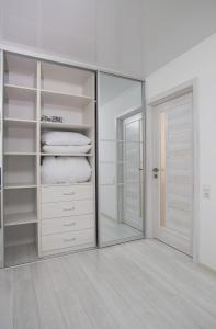 ein Ankleidezimmer mit einem Spiegel und einem Schrank in der Unterkunft Bilius Apartment in Winnyzja