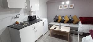 a small room with a sink and a couch at Studios Taha in Rabat