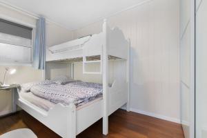 a white bunk bed in a white room at Seaside Holiday Home, great for fishing & hiking in Hellesøyni