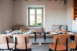 a dining room with tables and chairs and a window at Ruga of Vamvakou Homes in Vamvakoú