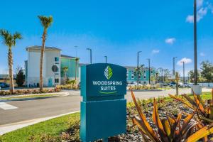 een bord voor een houtbewerkingsbedrijf op een parkeerplaats bij WoodSpring Suites Bradenton in Bradenton
