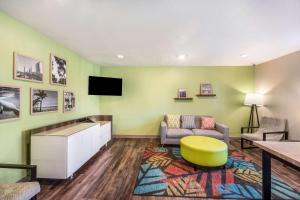 sala de estar con sofá y TV en WoodSpring Suites Bradenton en Bradenton