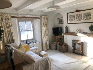 a living room with a couch and a fireplace at Sixpence Cottage in Penryn