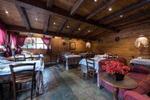 a dining room with tables and chairs and wooden walls at Hotel Val de Ruda in Baqueira-Beret