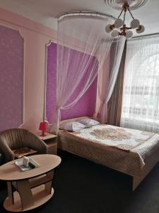 a bedroom with a bed and a chair and a table at Hotel ALTEYA in Moscow