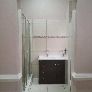 W łazience znajduje się umywalka i przeszklony prysznic. w obiekcie Esperamos w mieście Durban