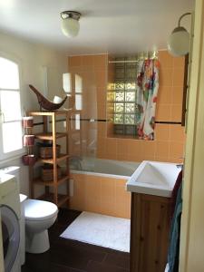 a bathroom with a tub and a toilet and a sink at Charmante ancienne maison garde-barrière Oise 25min Roissy in Betz