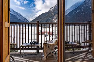 a balcony with chairs and a view of a mountain at Hotel Sant'Orso - Mountain Lodge & Spa in Cogne
