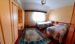 アヴェッツァーノにあるLa casa di Loryanneのベッド2台とラグ付きの小さなベッドルーム1室が備わります。