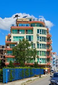 a tall building with a sign on top of it at Guest House California in Pomorie