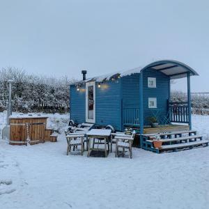a blue house with a table and chairs in the snow at Westfield House Farm in Rothbury