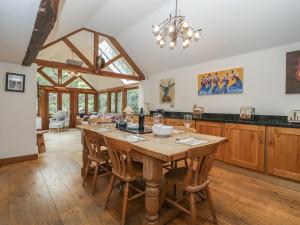 uma grande cozinha com uma mesa de madeira e cadeiras em Under Acre Cottage em Blandford Forum