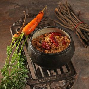 a pot of food with a carrot on a grill at Антиквар-отель мещанина Охлонина in Suzdal