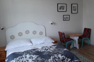 クリニツァ・ズドルイにあるWilla Halinówkaのベッドルーム1室(ベッド1台、椅子2脚、テーブル付)