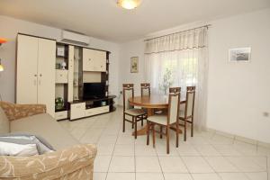 a living room with a table and chairs and a couch at Apartments Radosna in Šilo