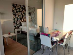 a room with a table and a bed and a mirror at DC Ghencea 158 Self Check-in in Bucharest