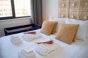 Una cama blanca con toallas y servilletas. en Nora Waterview, en Breda